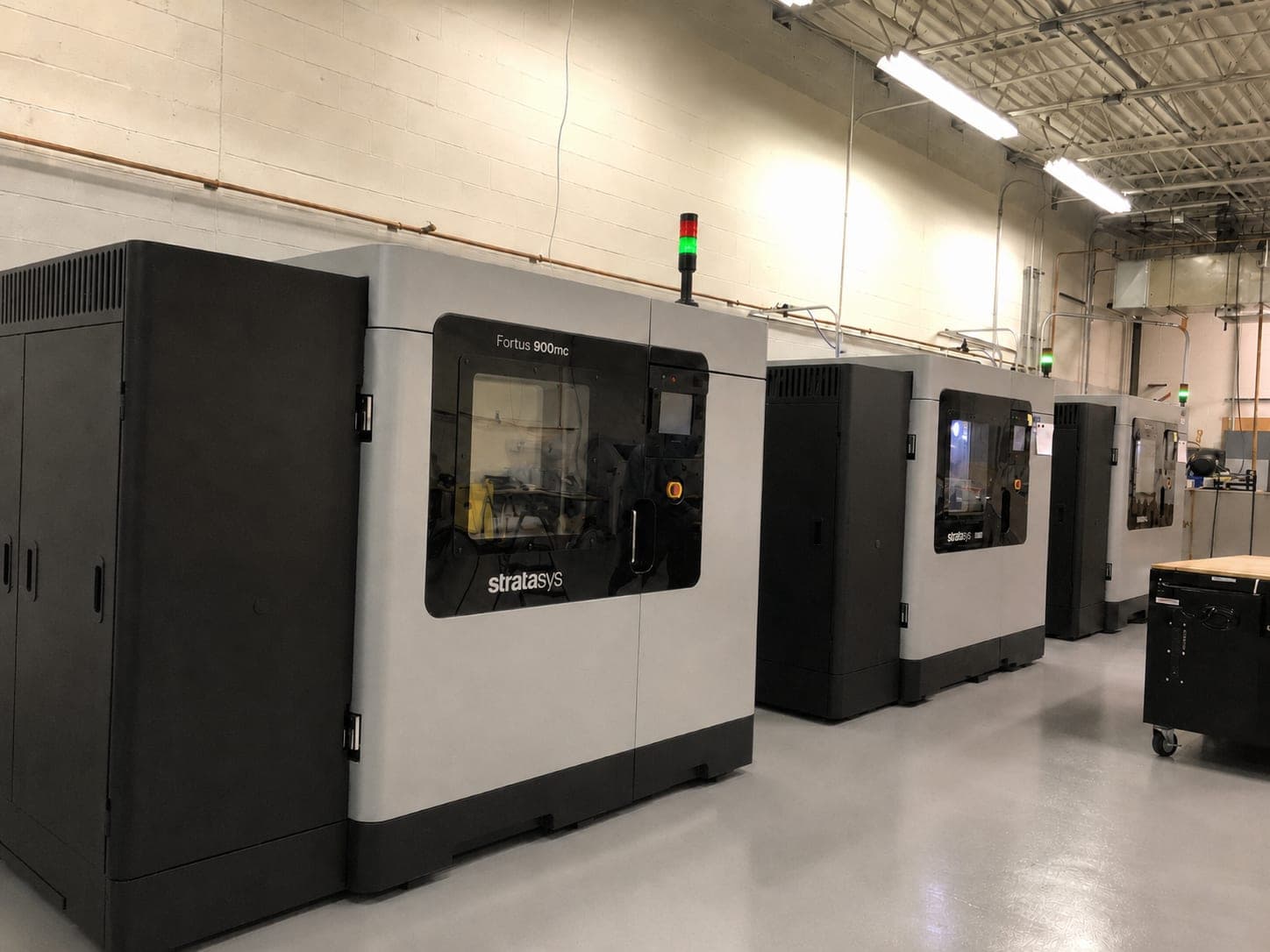 Row of Stratasys Fortus 900mc production printers on the American Additive shop floor